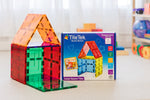 TileTek Expansion Pack large square tiles shown with a house built from the translucent coloured tiles and the retail box in a bright indoor room.